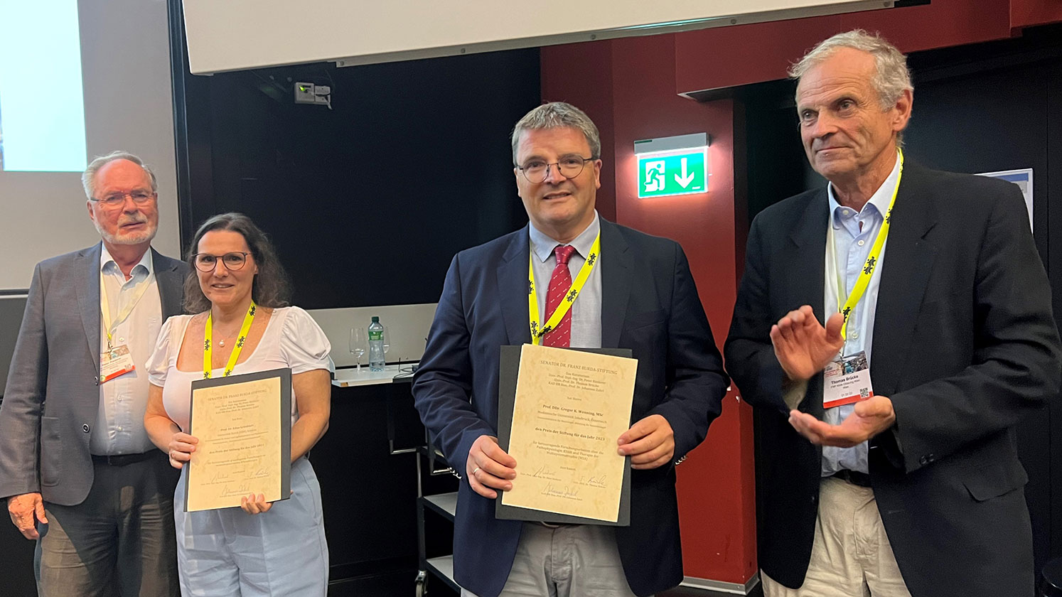 Prof. Dr. Edna Grünblatt und Prof. Dr. Gregor Wenning erhalten den Senator Dr. Franz Burda Award. (links im Bild: Prof. Peter Riederer, rechts im Bild: Prof. Dr. Thomas Brücke.)